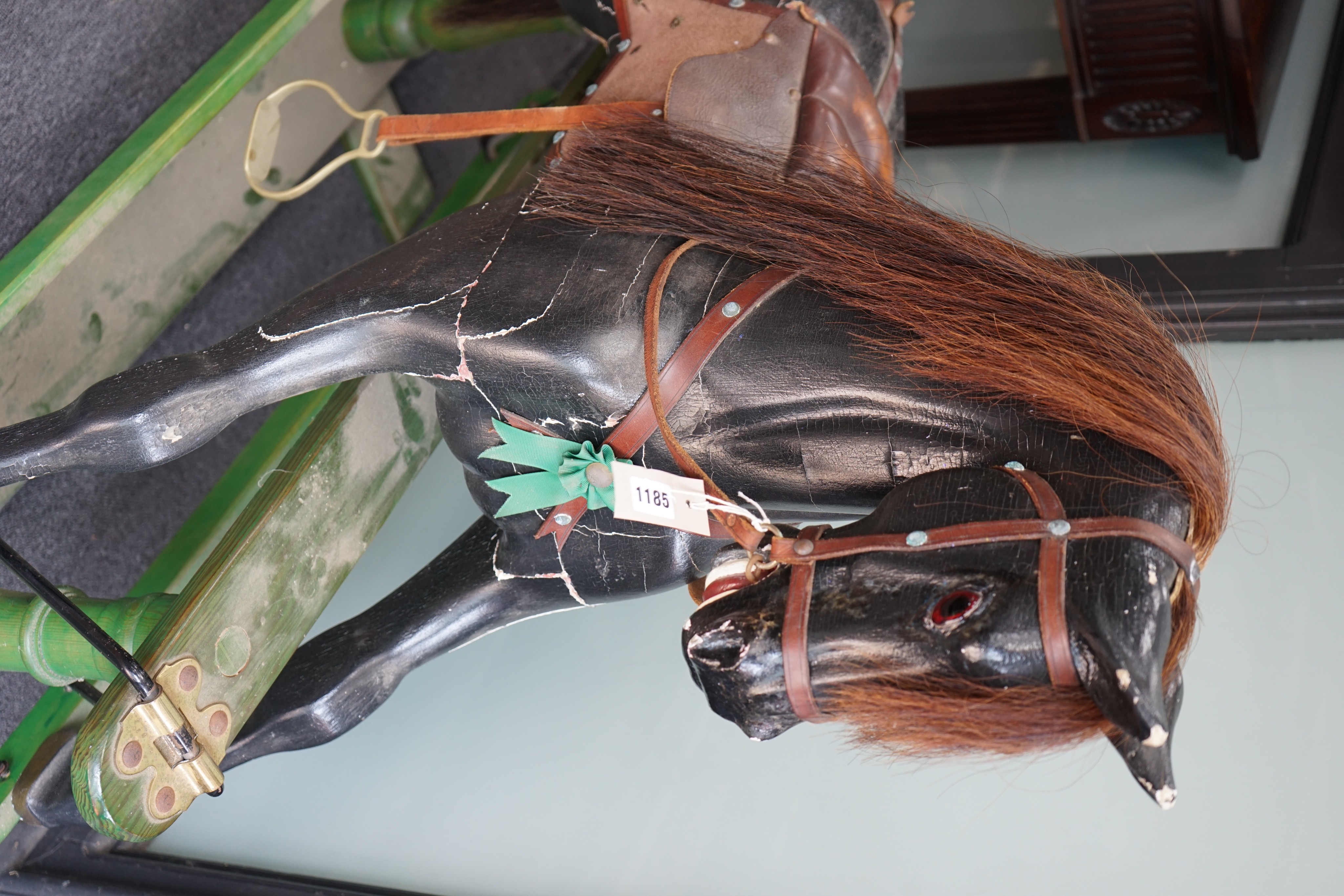 An early 20th century painted carved wood rocking horse on pine safety frame, length 132cm, height 107cm